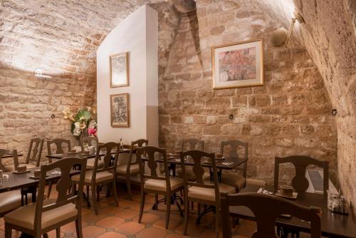 uma sala de jantar com mesas e cadeiras e uma parede de tijolos em Hôtel Belloy Saint Germain em Paris