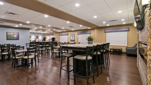 a restaurant with tables and stools in a room at Best Western Plus Lacombe Inn and Suites in Lacombe