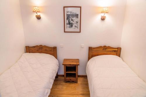 - 2 lits dans une chambre avec 2 lumières sur le mur dans l'établissement Résidence Les Hauts De Preclaux - Confortable appartement pour 8 personnes MAE-9191, aux Orres