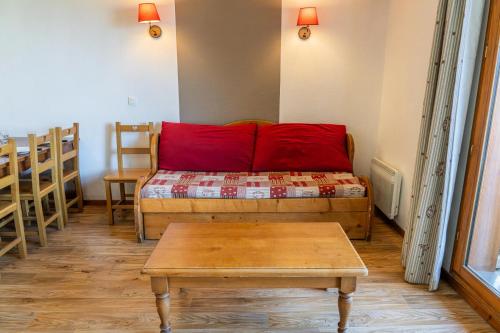 un salon avec un canapé rouge et une table dans l'établissement Résidence Les Hauts De Preclaux - Appartement en duplex au coeur des Orres 1800 MAE-9201, aux Orres