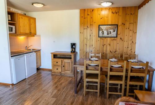 une cuisine avec une table et des chaises dans une pièce dans l'établissement Résidence Les Hauts De Preclaux - Appartement en duplex au coeur des Orres 1800 MAE-9201, aux Orres
