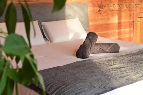 un lit avec deux serviettes dessus dans l'établissement BNB TOULOUSE - Le Chalet des coteaux - Cadre magnifique - WiFi - Parking, à Castelginest
