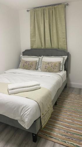 a bedroom with two beds with white sheets and pillows at New Guest House, Individual Ensuite Rooms with Comfortable Double Beds, TV and WiFi in Luton