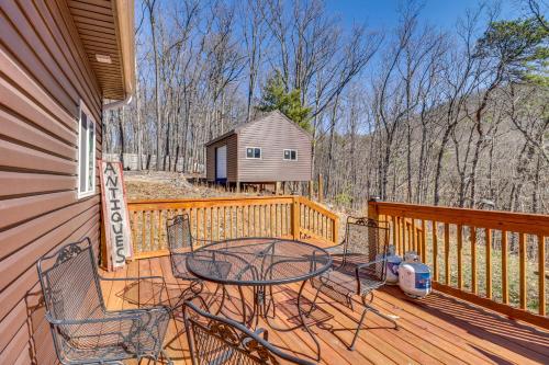 a patio with a table and chairs on a deck at Pet-Friendly Shenandoah Cabin with Fire Pit and Grill! in Shenandoah