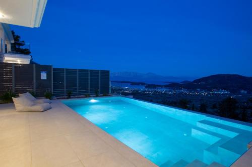 a swimming pool on top of a building at night at Oriens Villas in Palaiokhóri