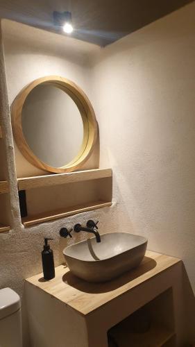 une salle de bain avec un lavabo et un miroir dans l'établissement Le Monde, à Lamastre