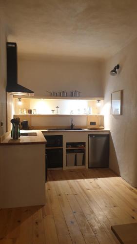 une grande cuisine avec un comptoir et un îlot de cuisine dans l'établissement Le Monde, à Lamastre