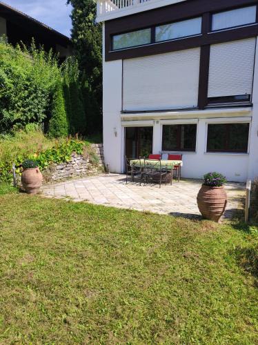 a house with a patio with two chairs and a table at Helle Wohnung in Seenähe in Berg am Starnberger See