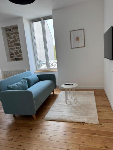 a living room with a blue couch and a table at Résidence des Quais - Centre ville - Wifi - Netflix in Quimper