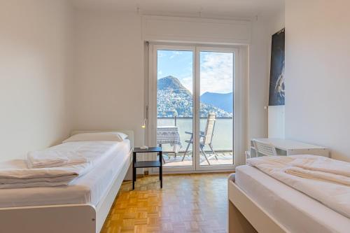 Postel nebo postele na pokoji v ubytování Imperial of Lugano 4 with a lake view behind the station and 10 min from the lake