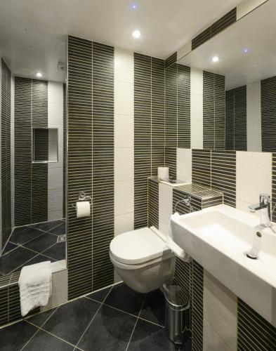 a bathroom with a toilet and a sink and a shower at New Linden Hotel in London
