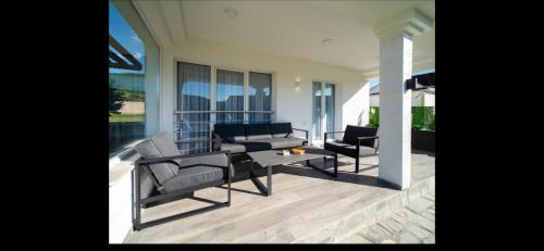 a living room with chairs and a table on a porch at Vila Tom & Jerry in Raška