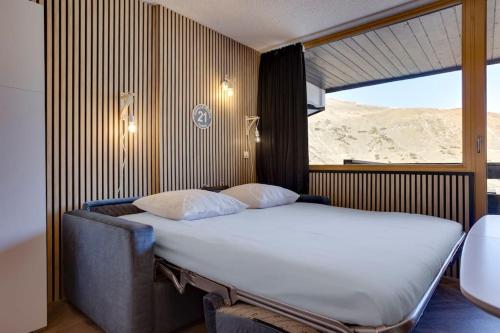 Una cama grande en una habitación con una ventana grande. en Au 6ème ciel Tignes 2100m - Vue Lac & Montagnes - Proche pistes - 2 adultes et 2 enfants, en Tignes
