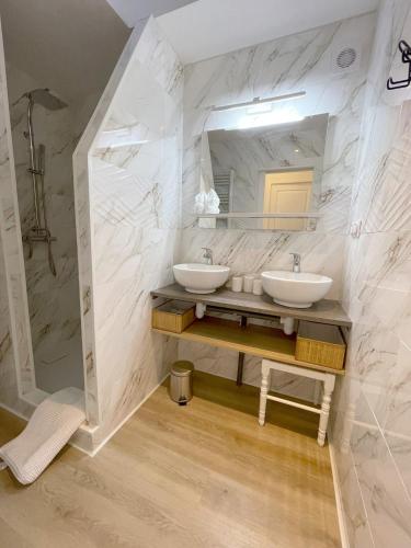 une salle de bain avec deux lavabos et un miroir dans l'établissement Maison Les Coquelicots - Wifi, Calme, Parking privé, à Hem-Lenglet