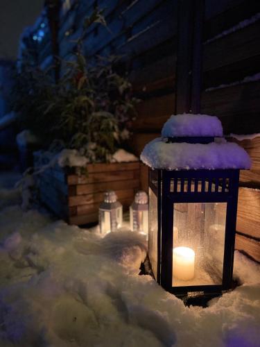 a lantern covered in snow with a candle at Gîte Studio Alsa 15 avec Jacuzzi privatif in Fortschwihr