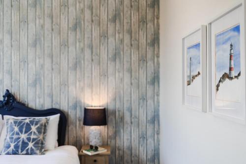 a bedroom with a bed and a lamp on a night stand at The White Swan Hotel in Greytown