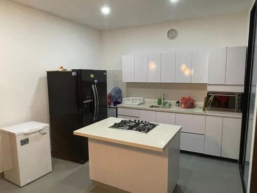a kitchen with a black refrigerator and white cabinets at Espectacular Casa de Verano in Carmen de Apicalá