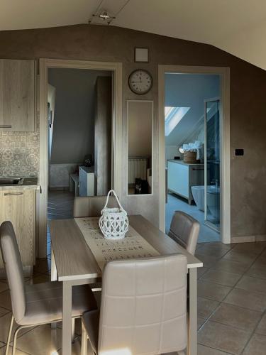 a dining room with a table and chairs and a clock at G house in Leinì