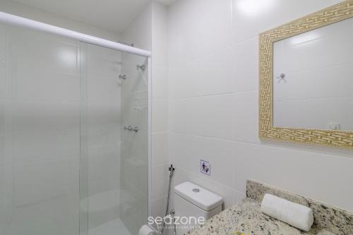 a bathroom with a shower and a toilet and a mirror at Encantador apto em Cabo Frio SDA311 in Škorak
