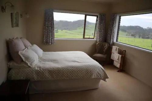 a bedroom with a bed and a large window at Luxury Countryside Retreat - Totara Valley in Ohaeawai