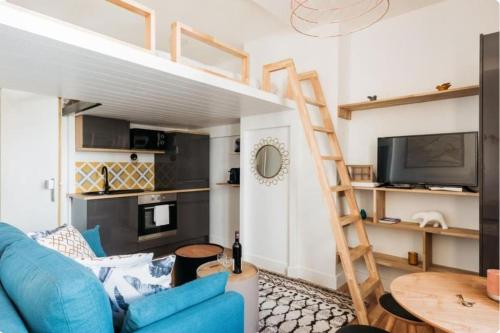 a living room with a blue couch and a loft bed at Bancel- Jean Macé in Lyon