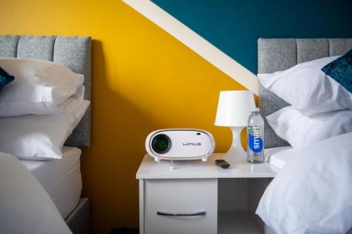 a bedroom with two beds and a tv on a night stand at Cosy townhouse, new build, 5 bedrooms, Sleeps 8, Free Parking in Northfleet
