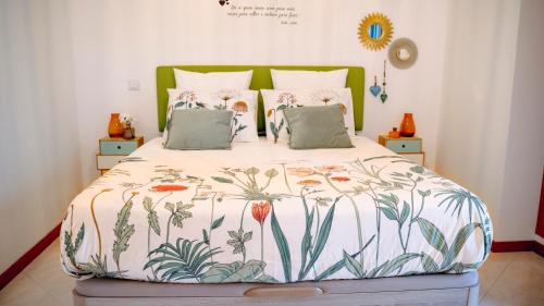 een slaapkamer met een groot bed met een sprei met bloemen bij Wonderful Apartment in Ferragudo 2Double Beds near Beaches and Golf in Ferragudo