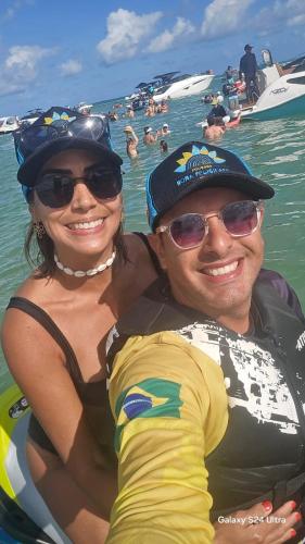 a man and woman in the water at the beach at Pousada Dona Felicidade Carneiros in Tamandaré