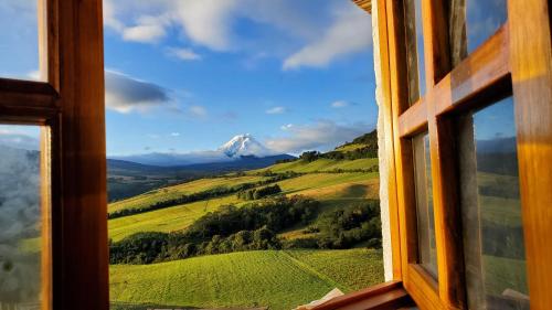 a view of a mountain from a window at Balcon al Cotopaxi Hosteria in Sangolquí