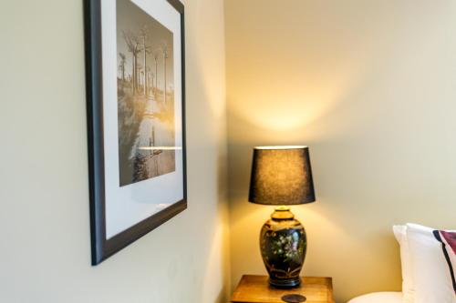 a lamp on a table in a room with a picture at The White Swan Hotel in Greytown