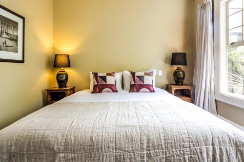 a bedroom with a large bed with two lamps at The White Swan Hotel in Greytown
