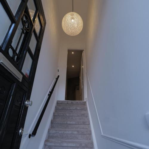 a hallway with stairs and a chandelier at Living Room Apartments in Rotterdam