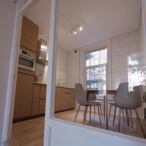 a kitchen with a table and chairs and a window at Living Room Apartments in Rotterdam