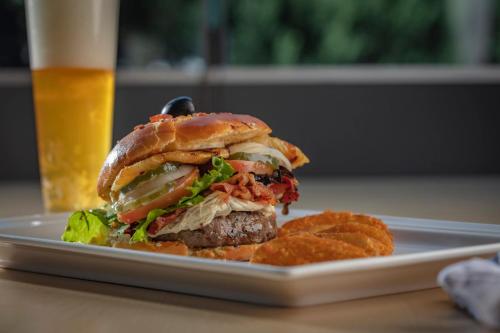 a sandwich and chips on a plate with a beer at Holiday Inn Puebla La Noria by IHG in Puebla
