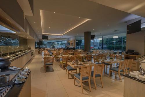 a restaurant with wooden tables and chairs in a room at Holiday Inn Puebla La Noria by IHG in Puebla