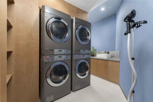 three washing machines are in a laundry room at Holiday Inn Express Datong Pingcheng by IHG in Datong