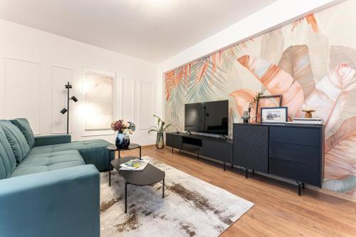 a living room with a blue couch and a tv at XOX Comfort Giurgiului in Bucharest