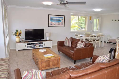 a living room with a couch and a tv at Carrington 6 in South West Rocks