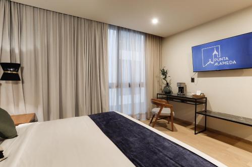 a hotel room with a bed and a flat screen tv at Punta Alameda in Mexico City