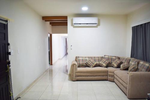 a living room with a couch and a air conditioner at Amplia casa cerca malecón in La Paz