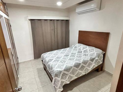 a bedroom with a bed with a blanket on it at Amplia casa cerca malecón in La Paz