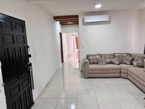 a living room with a couch and a door at Amplia casa cerca malecón in La Paz