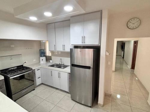 a kitchen with a stainless steel refrigerator and a sink at Amplia casa cerca malecón in La Paz