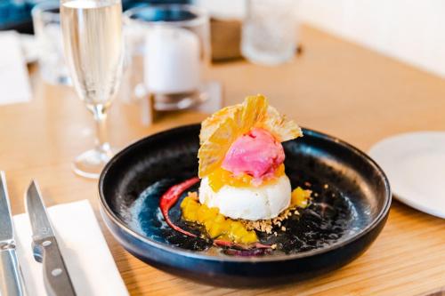 a black plate with a dessert on a table at The White Swan Hotel in Greytown