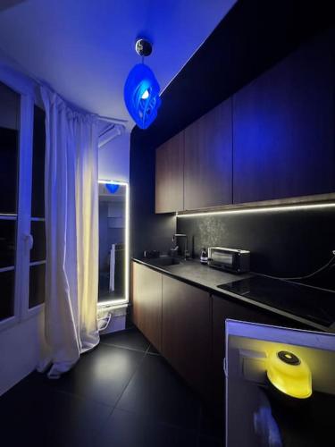 une cuisine avec une lumière bleue et un comptoir de cuisine dans l'établissement Charming Paris Studio Apartment, à Paris