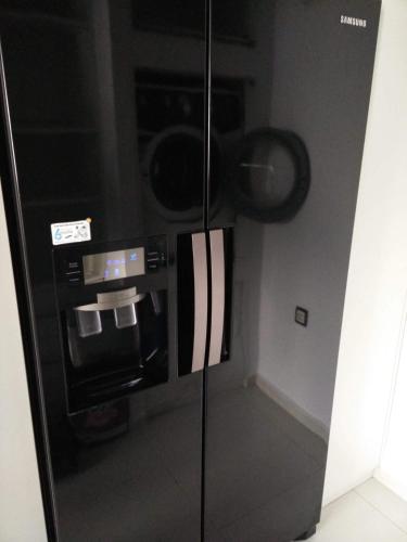 a black refrigerator with a coffee maker in a room at Moderne Ruheoase in Piaseczno