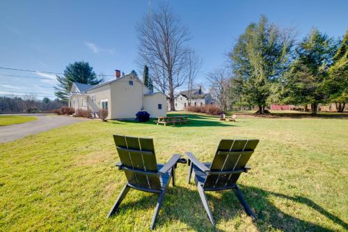 two chairs sitting in a field in front of a house at Less Than 4 Mi to Cooperstown Charming Historic Home! in Fly Creek