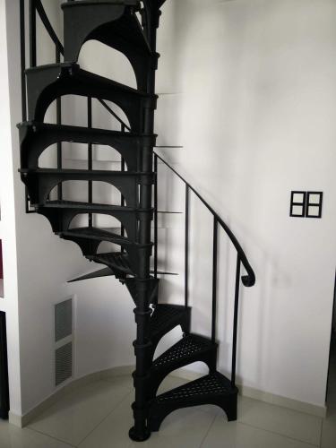 a black spiral staircase in a white room at Moderne Ruheoase in Piaseczno