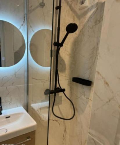 une douche avec une porte vitrée dans une salle de bain dans l'établissement Studio Coup de Cœur Ménilmontant, à Paris