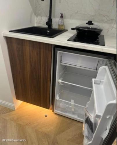  La cuisine est équipée d'un réfrigérateur ouvert et d'une cuisinière. dans l'établissement Studio Coup de Cœur Ménilmontant, à Paris